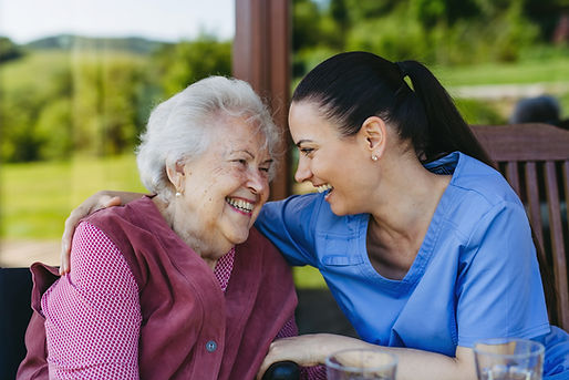 Portrait of female caregiver and senior woman. Nurse and elderly woman enjoying a warm day