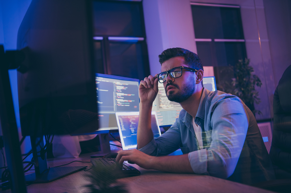 Man looking at bank of computer screens