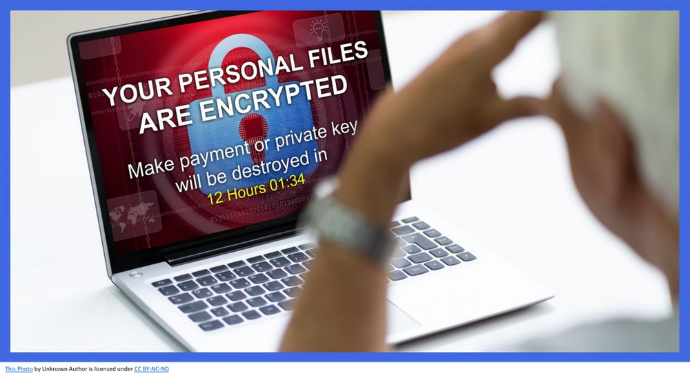 Image of person starting at computer screen with ransomware message