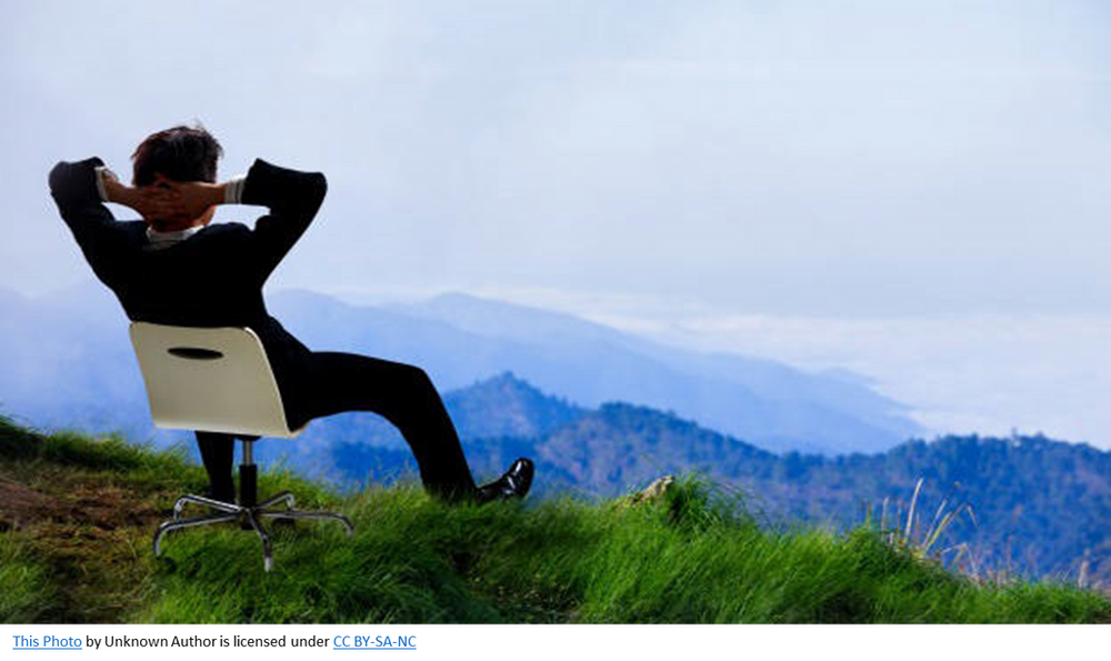 Man in suit, sitting in chair relaxing overlooking scenic view