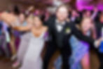 The bride and groom lead a dance on the dance floor, surrounded by enthusiastic guests at the Barn at shade Lane