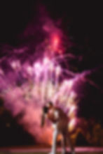 Couple kissing at night with vibrant fireworks in the background, at a wedding near the Barn at Smith Lake.