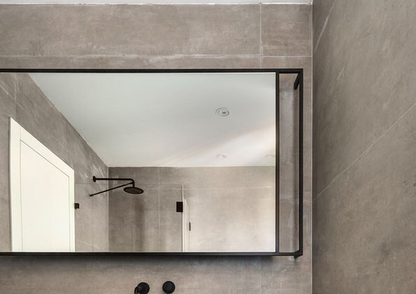 מראה מלבנית עם מסגרת ברזל בשילוב פרט ניתוק משני 
.צדדי המראה ובהרחקה מהקיר גימור שחור מט.
עיצוב פנים: ניצן הורוביץ
צילום: עודד סמדר