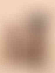 One adult dog and one puppy sitting side by side on beige background