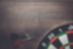 target-and-two-darts-on-a-wooden-table