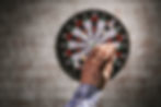 A man aiming at a Bristle or a Sisal Dartboard