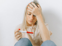 woman looking depressed at a pregnancy test as historic vote increases searches for walk-in abortion clinic near me and abortion pills.