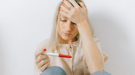 woman looking depressed at a pregnancy test as historic vote increases searches for walk-in abortion clinic near me and abortion pills.