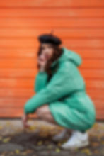 stylish-woman-posing-winter-autumn-fashion-trend-puffer-coat-hat-beret-against-orange-wall
