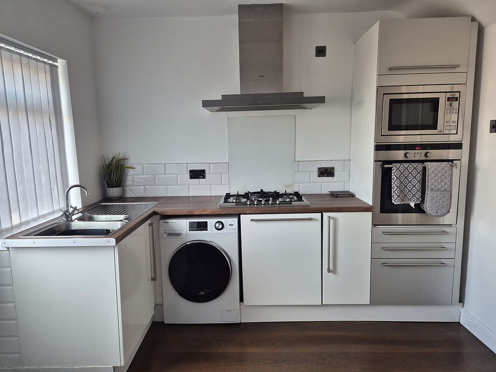 Modern white kitchen with integrated appliances in Chirk