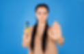 a girl on a blue background holds a disposable cigarette in one hand and shows a stop to s