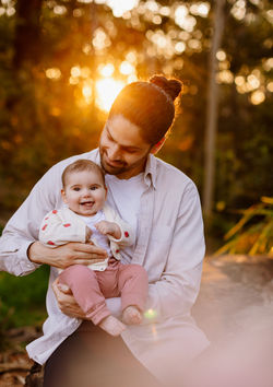 Father daughter laughing in the forest at sunset