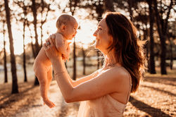 Sunset photo of mum and newborn girl looking at each other