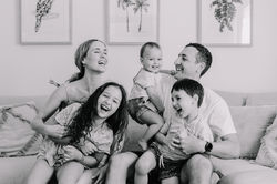 Black and white candid of a family of five mid way through laughing