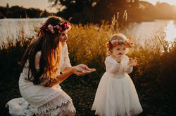 Sunset in the park in front of a pond with mother and daughter looking at the flowers