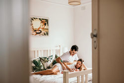 Couple looking down at their newborn son on their bed