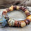 Thumbnail: Photo of the of the Alcobaca Bracelet on a piece of driftwood.