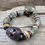 Thumbnail: Photograph of the Nomad Bracelet on a piece of driftwood.