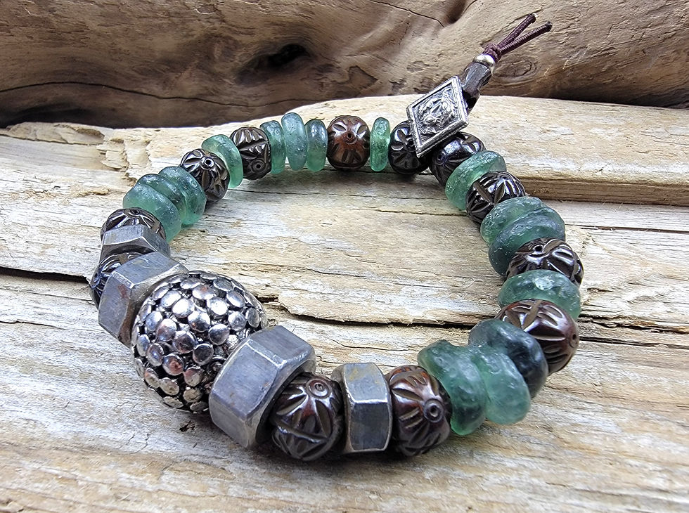Thumbnail: Photograph of the Islands to Highlands Stirling Bracelet on a piece of driftwood.