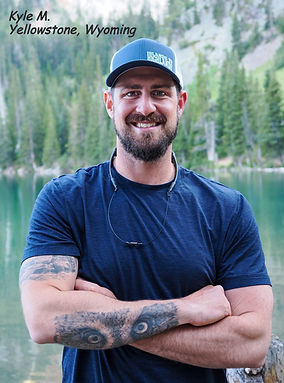 Photograph of a man wearing an Islands To Highlands Pacific Cap in Yellowstone, Wyoming with trees and a lake in the background.