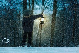 un hombre con una linterna de aceite  alumbrándose