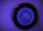 Nest thermostat set to cooling at 75°F, glowing with a vivid purple hue against a dark background.
