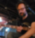 Greg holding a bass in a basement
