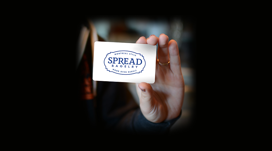 Spread-Gift-Card-Mock-Hand-Black-Logo.pn
