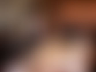 Professional meeting with diverse individuals in business attire around a table. A woman is standing and speaking. Mood is focused.