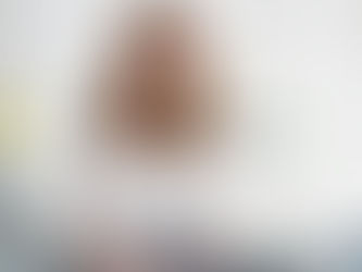 Smiling woman with glasses holds tablet in bright office. Laptop, colorful books, and plant visible. Calm and professional mood.