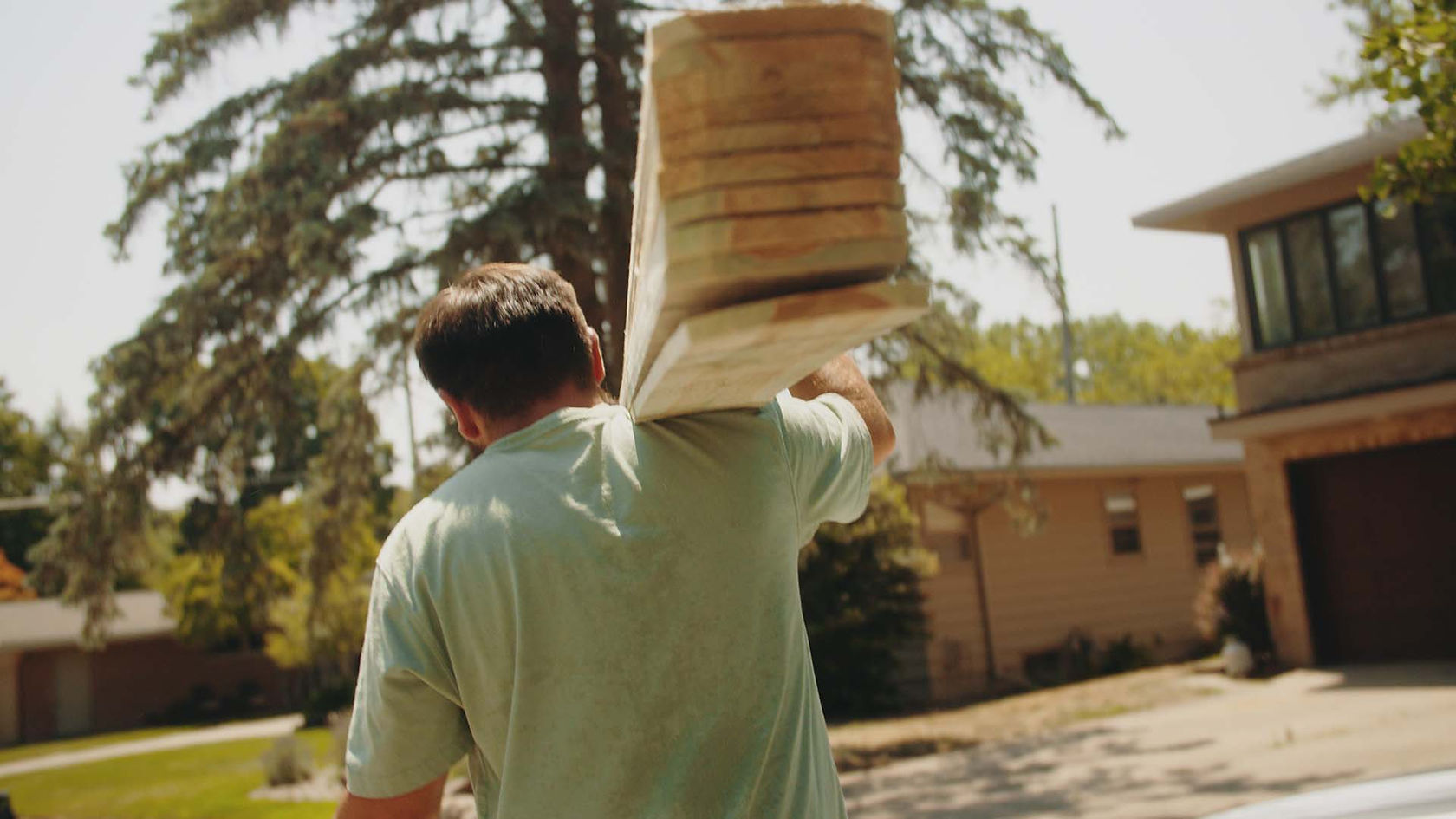 fence brothers contractor carrying wood fence pickets