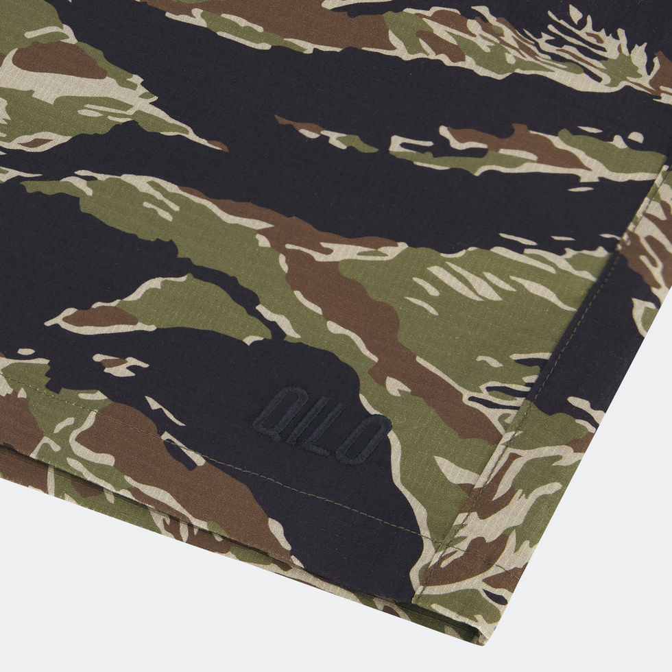 Detailed close-up of QILO logo on tiger stripe QILO EDC Mk. II shorts