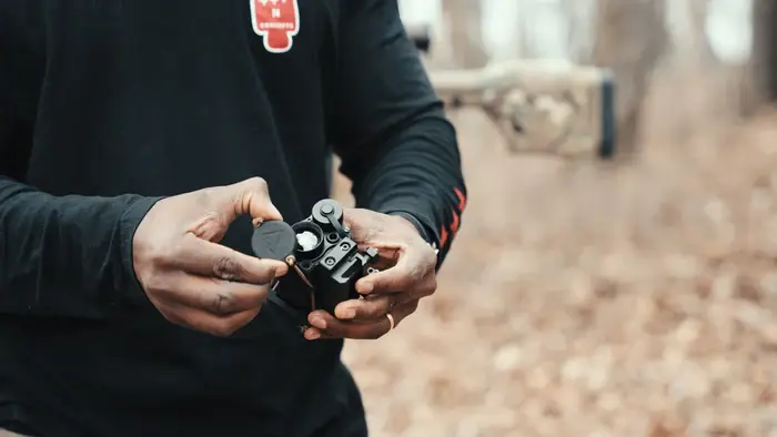 A person outdoors in his hands a One Hundred Concepts ThermalCap on a RH25 thermal device