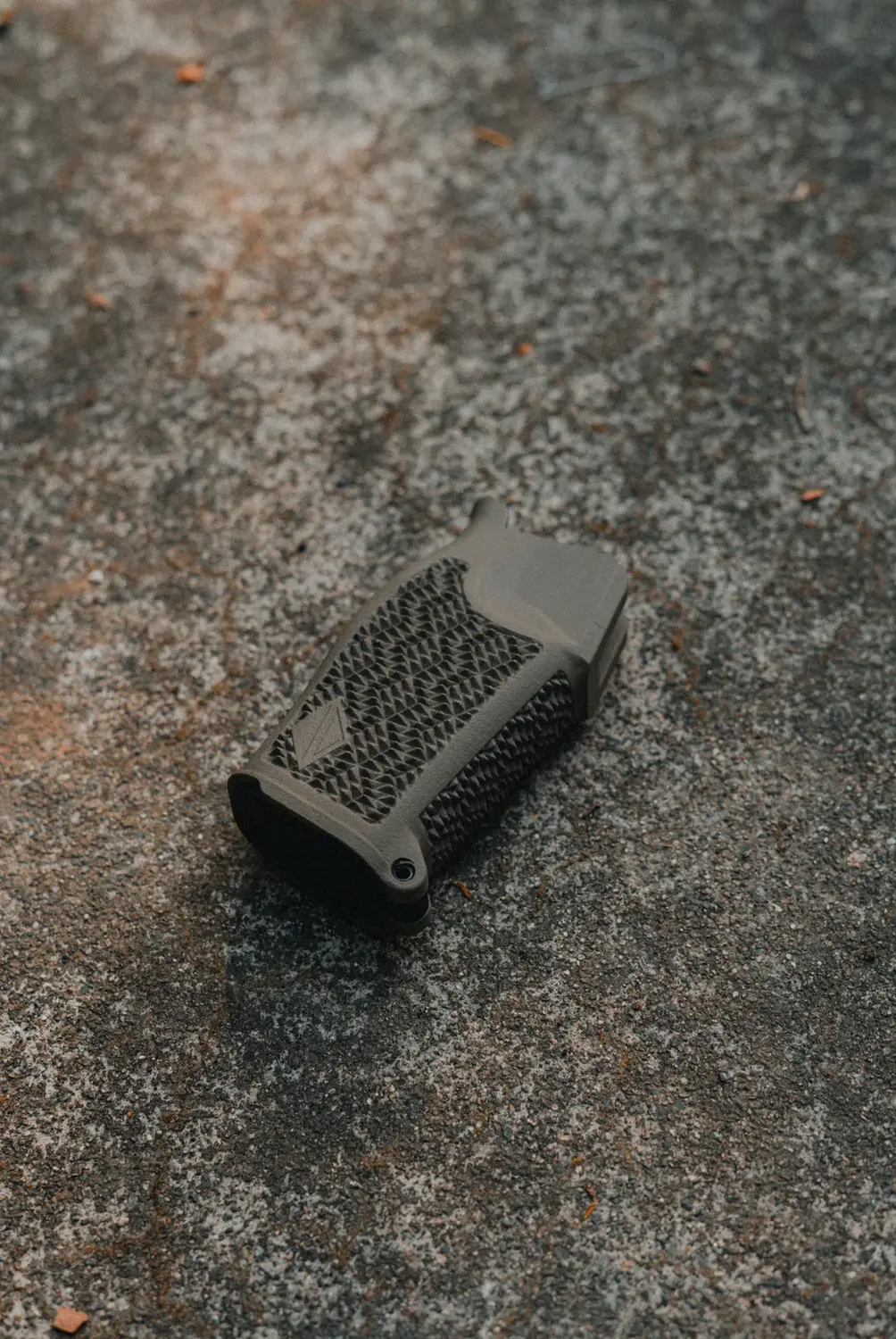 Top view of Irregular Defense Special-K XL TD grip in FDE color, on a grainy background