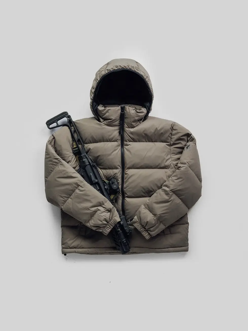 QILO x SC Irregulars LHOTSE down puffer in Maritime Grey front view. An MCX rifle is placed on top of the jacket.