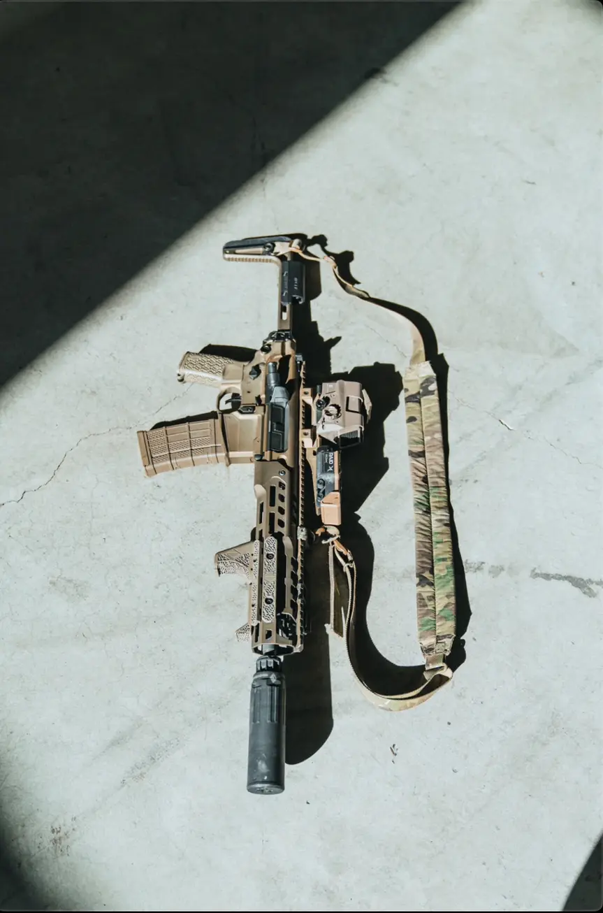 MCX rifle equipped with red dot, suppressor, sling and a black Irregular Defense FEER MCX MF (Minimalist Folding)