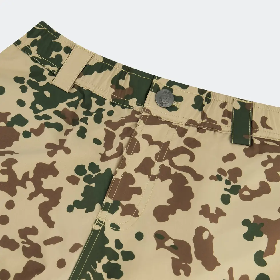 Close-up details of QILO x WRMFZY Driftwood Pants in Tropentarn, showing WRMFZY logo on the button