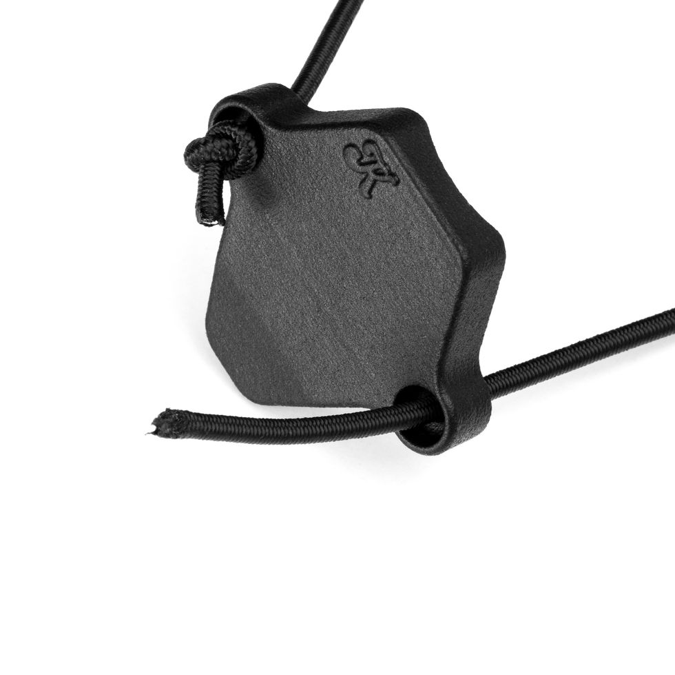 An elastic paracord is routed through the loop on the side of KOLIBRI.works DEKEL for attaching it to a rifle light