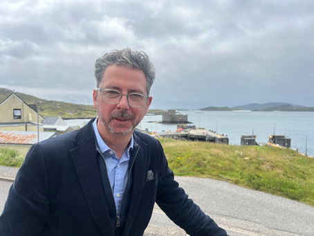 torcuil crichton mp standing with Castlebay in the background