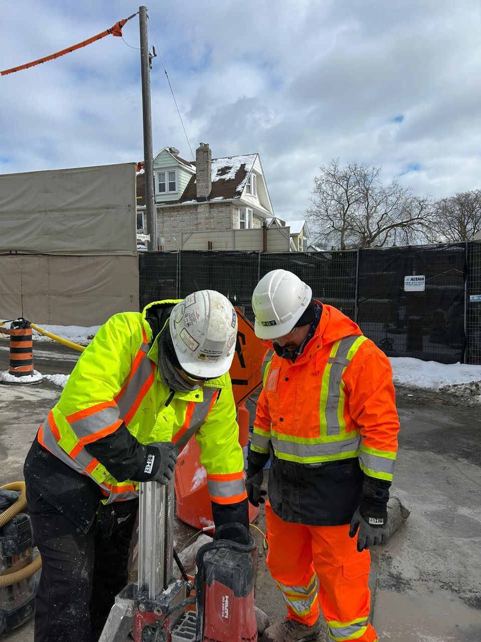 PGT technicians in safety gear operating ground-testing equipment at a construction site.