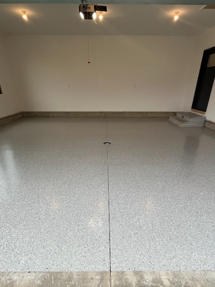 "After image of a garage featuring a glossy epoxy floor, showcasing a smooth and polished finish that enhances the space. 