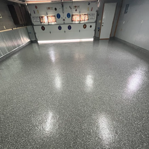 "After image of a garage featuring a glossy epoxy floor, showcasing a smooth and polished finish that enhances the space. 