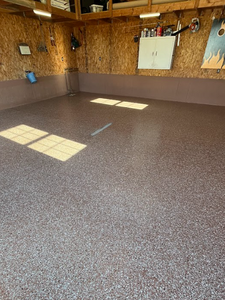 "After image of a garage featuring a glossy epoxy floor, showcasing a smooth and polished finish that enhances the space. 