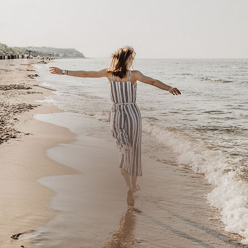 Woman walking along beach (striped dress).jpg