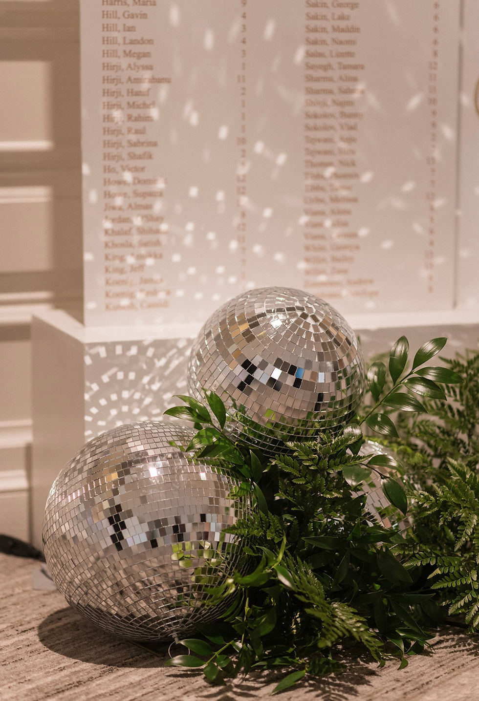 A disco ball illuminating a wedding guest seating chart