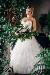 Bride in white wedding dress holds bouquet