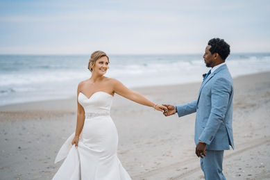 Bride and groom holding hands on beach Wedding