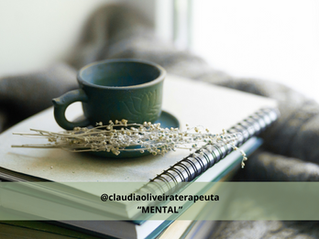 Um caderno e sobre ele uma xicara, um pires e um ramo de flor