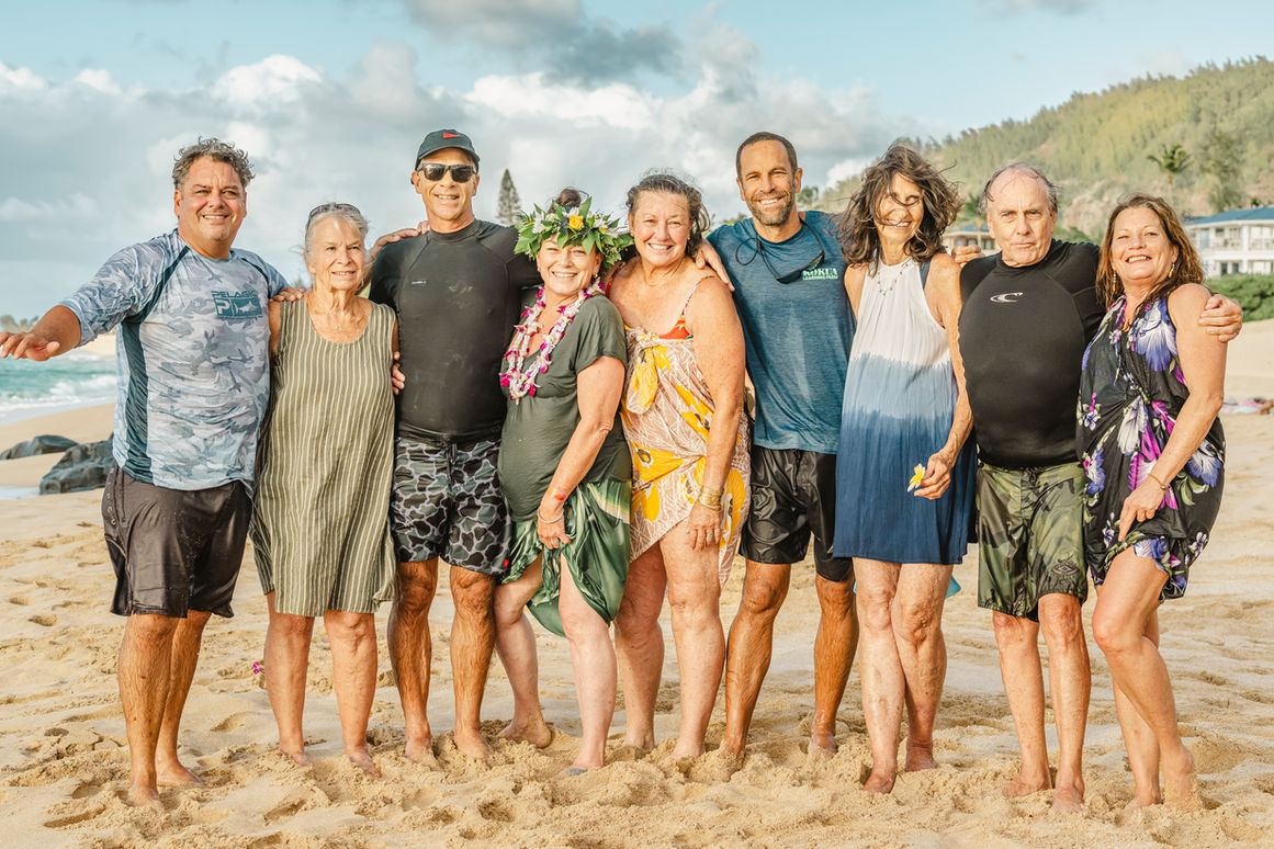 A group of good friends get together at Rockpiles on the North Shore for a paddle out in memory of a mother. Oahu, Hawaii. 