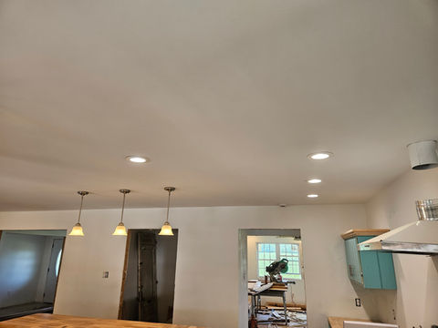 Recessive lights, ceiling fan with light, and hanging lights.